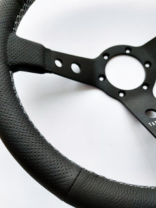 Custom steering wheel in black aluminum with air-cooled leather by Tactico Racing Atelier